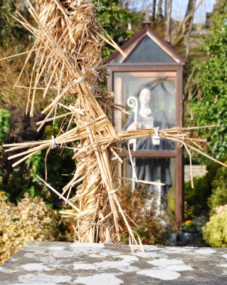 An hay arch (hay wrapped over a metal frame) covers the entrance to the well, it is adorned with St Brigid's Crosses